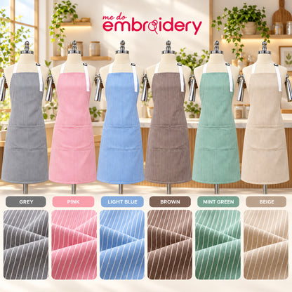 Six aprons in different colors are displayed on dress forms in a bright kitchen-like setting, with the brand name 'me do embroidery' at the top. The aprons are shown in grey, pink, light blue, brown, mint green, and beige, all with a pinstripe pattern.