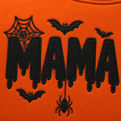 Detailed view of black dripping MAMA embroidery with bats and a dangling spider on a bright orange Halloween crewneck sweatshirt.