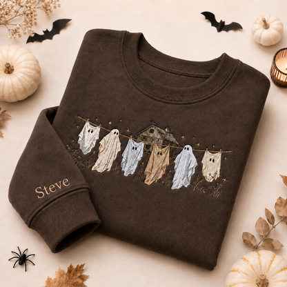 Custom embroidered ghost sweatshirt in dark brown featuring ghosts hanging on a clothesline with a haunted house and personalized sleeve name.