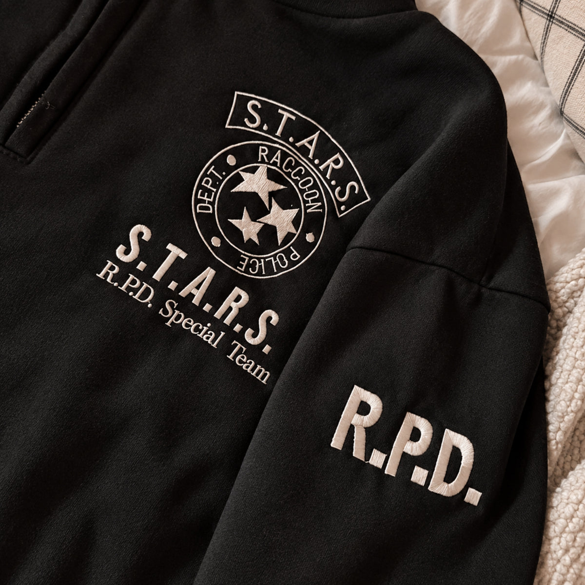 Black crewneck sweatshirt featuring white embroidered S.T.A.R.S. Raccoon Police Department emblem, “S.T.A.R.S. R.P.D. Special Team” chest text, and large “R.P.D.” sleeve embroidery.