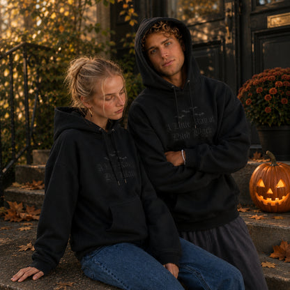 Couple wearing matching spooky season hoodies featuring black on black embroidered gothic lettering and bat embroidery, creating the perfect Halloween and fall matching outfit.